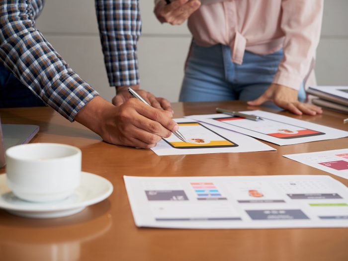 Hands of product manager making corrections on interface image