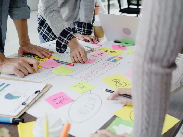 Group of casually dressed business people discussing ideas in the office. Creative professionals gathered at the meeting table for discuss the important issues of the new successful startup project.