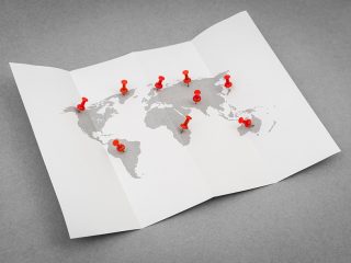 Paper folded world map  with red Pin Pointer